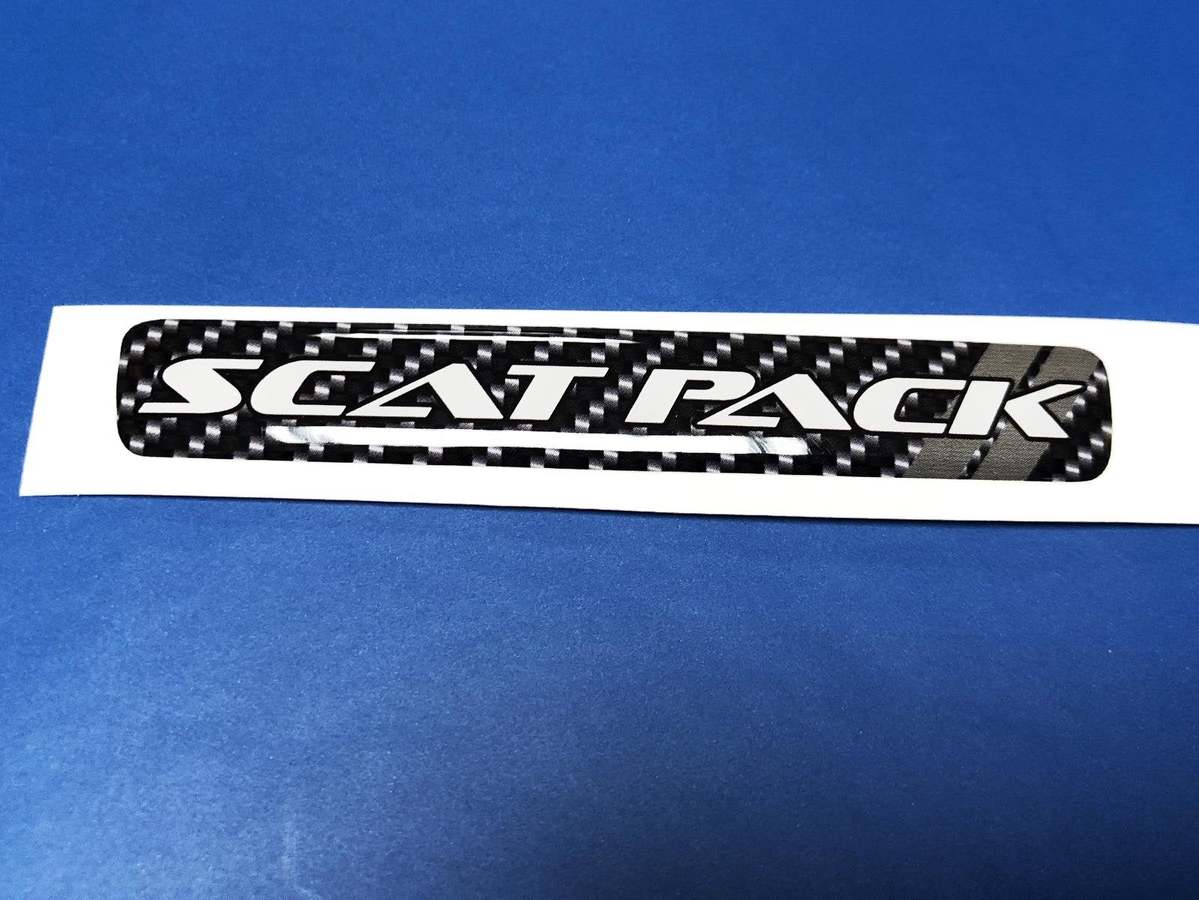 Ein Lenkrad-Scatpack-Emblem mit grauen Streifen und gewölbtem Aufkleber aus Kohlefaser
